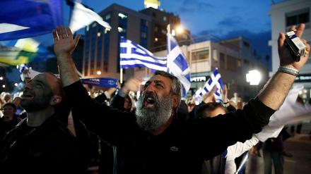Ein Unterstützer des konservative Politikers Nikos Anastasiades feiert auf der Straße.