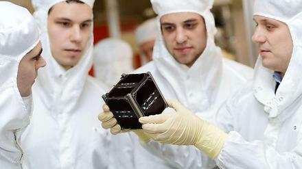 In die Forschung eingebunden. Doktoranden und Studierende der Universität Würzburg mit einem von ihnen entwickelten Kleinsatelliten.
