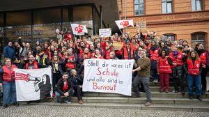 Streikende Lehrer stehen vor der Mensa Nord der Humboldt Universität und halten ein Transparent mit der Aufschrift „Stell dir vor, es ist Schule und alle sind im Burnout“.