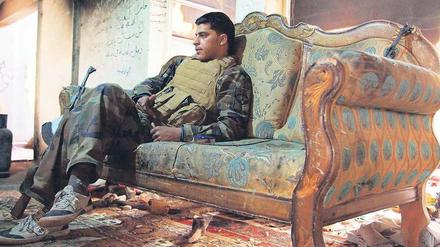 Kampfpause. Ein Kämpfer der syrischen Rebellen ruht sich in einem Privathaus in der Stadt Deir as-Saur aus, dessen Bewohner offenbar vor dem Krieg geflohen sind. Die historische Stadt im Osten des Landes ist stark zerstört worden. Regierungstruppen und die offenbar sehr gut ausgerüsteten Rebellen lieferten sich hier schwere Gefechte.