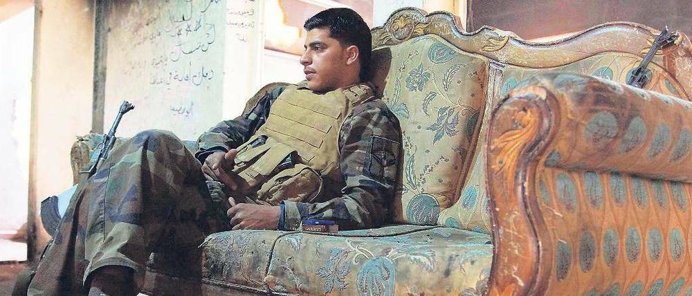 Kampfpause. Ein Kämpfer der syrischen Rebellen ruht sich in einem Privathaus in der Stadt Deir as-Saur aus, dessen Bewohner offenbar vor dem Krieg geflohen sind. Die historische Stadt im Osten des Landes ist stark zerstört worden. Regierungstruppen und die offenbar sehr gut ausgerüsteten Rebellen lieferten sich hier schwere Gefechte.