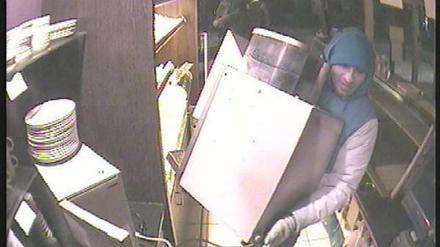 Hier transportiert einer der Verdächtigen den Kaffeeautomaten ab. Im Hintergrund wartet sein mutmaßlicher Komplize.