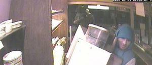 Hier transportiert einer der Verdächtigen den Kaffeeautomaten ab. Im Hintergrund wartet sein mutmaßlicher Komplize.