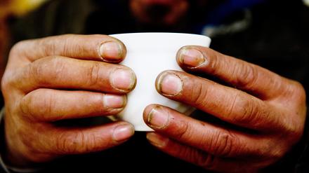 Ein obdachloser Mann hält in einem Nachtcafé eine Tasse. (zu dpa «Städte halten Quartiere für wohnungslose Menschen bereit») +++ dpa-Bildfunk +++