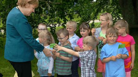Bundeskanzlerin Angela Merkel wird am 31.05.2013 in der SOS-Dorfgemeinschaft Grimmen (Mecklenburg-Vorpommern) von Kita-Kindern zum SOS-Jahresempfang begrüßt. 