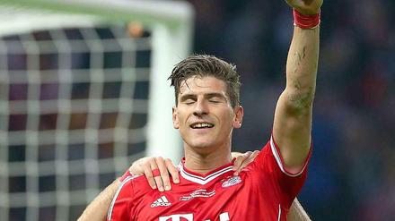 Mario Gomez hat die Augen geschlossen und jubelt nach einem Tor mit in die Luft gestreckter Faust.