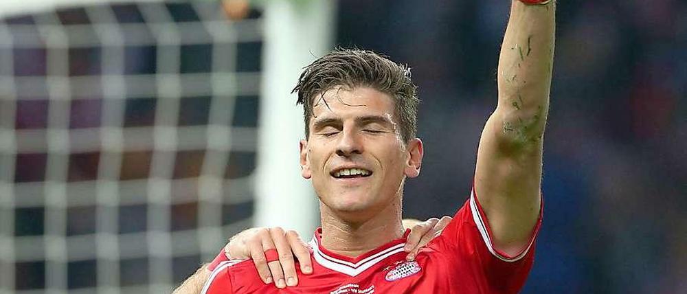 Mario Gomez hat die Augen geschlossen und jubelt nach einem Tor mit in die Luft gestreckter Faust.