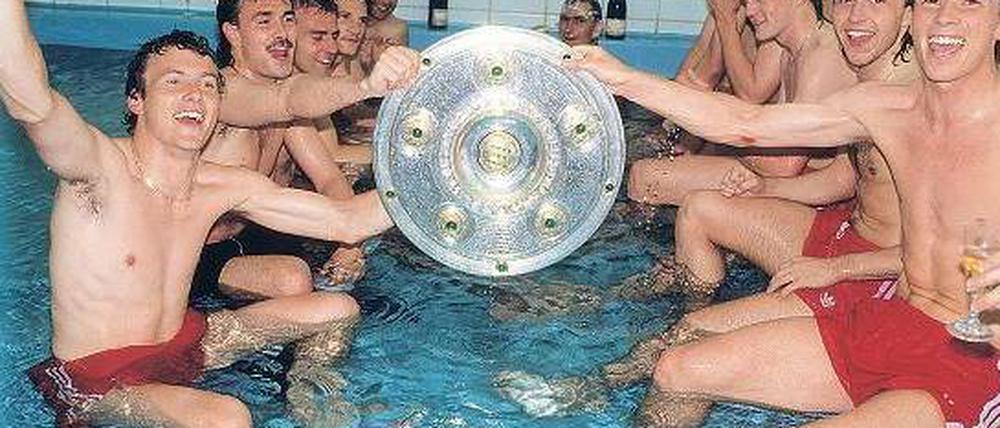 Die Bundesliga, wie sie lebt und feiert. Halbnackt, aber dafür in Schale bejubeln die Spieler des FC Bayern München Roland Grahammer, Raimond Aumann (links von vorne), Stefan Reuter und Jürgen Wegmann (rechts von vorne) die Meisterschaft 1989. Foto: Imago
