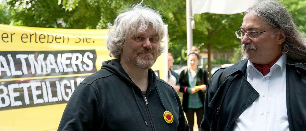 zwei Mänenr vor Protestplakat