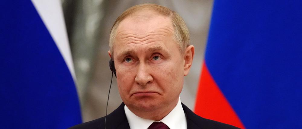 15.02.2022, Russland, Moskau: Russlands Präsident Wladimir Putin schaut auf einer gemeinsamen Pressekonferenz mit Bundeskanzler O. Scholz (SPD) nach einem mehrstündigen Vier-Augen-Gespräch im Kreml. Scholz traf den russischen Präsidenten zu Gesprächen über die Situation an der ukrainischen-russischen Grenze. Formal handelt es sich um einen Antrittsbesuch des Kanzlers.