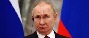 15.02.2022, Russland, Moskau: Russlands Präsident Wladimir Putin schaut auf einer gemeinsamen Pressekonferenz mit Bundeskanzler O. Scholz (SPD) nach einem mehrstündigen Vier-Augen-Gespräch im Kreml. Scholz traf den russischen Präsidenten zu Gesprächen über die Situation an der ukrainischen-russischen Grenze. Formal handelt es sich um einen Antrittsbesuch des Kanzlers. 