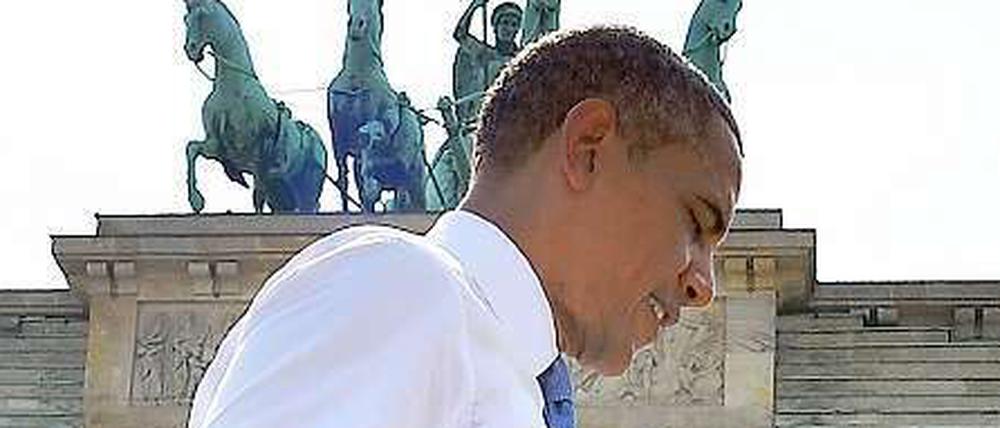 Das Bild zeigt US-Präsident Barack Obama vor dem Brandenburger Tor, ohne Jackett und mit leicht gequältem Gesichtsausdruck.