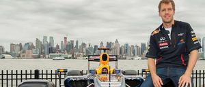 Sebastian Vettel sitzt auf dem reifen seines Formel-1-Autos.