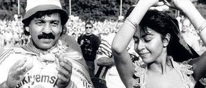 Ein Türkiyemfan und eine Bauchtänzerin tanzen auf einem Fußballplatz.