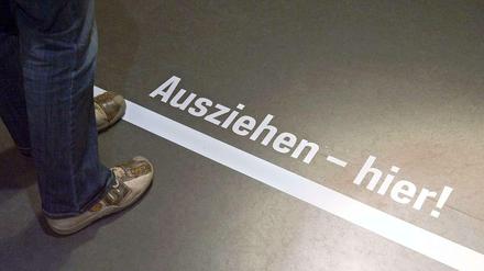 Ein Schriftzug auf dem Boden der lautet: Ausziehen- hier!