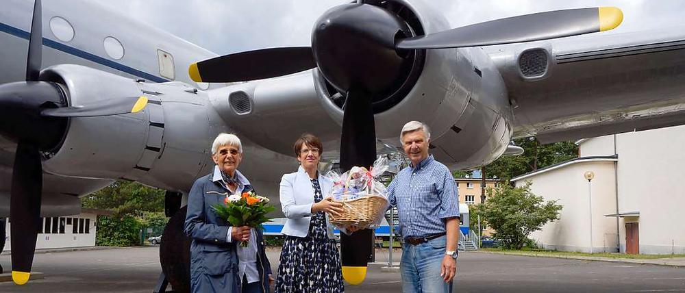 Unterm Rosinenbomber. Museumsleiterin Gundula Bavendamm (Mitte) mit dem einmillionsten Besucher Wilfried Metasch (re.) und seiner Frau Irmgard.