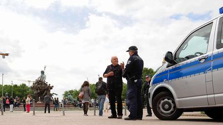 Alltag und Ausnahmezustand. Zwei Tage nach dem tödlichen Schuss posieren Touristen vor dem Neptunbrunnen, Kerzen erinnern an das Opfer.
