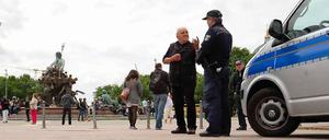 Alltag und Ausnahmezustand. Zwei Tage nach dem tödlichen Schuss posieren Touristen vor dem Neptunbrunnen, Kerzen erinnern an das Opfer.
