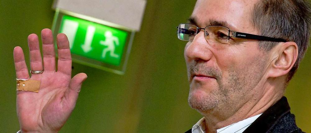 Matthias Platzeck hebt bei einem Landesparteitag im März die Hand zum Gruß, er trägt ein Pflaster an der Handkante.