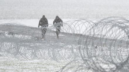 Soldaten des polnischen Militärs patrouillieren hinter Stacheldraht nahe der ukrainischen Grenze.