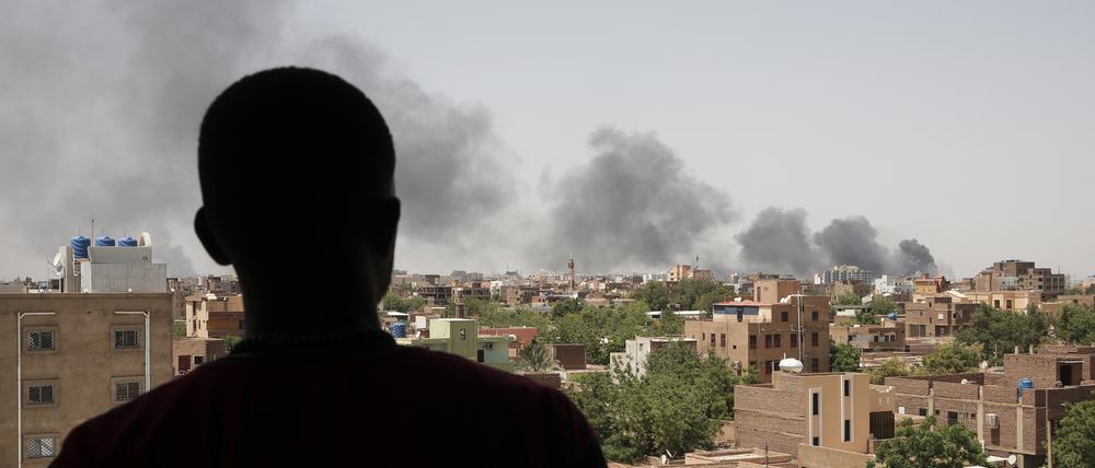 Ein Mann blickt auf die Stadt Khartum, wo während der Kämpfe im Susan schwarzer Rauch aufsteigt.