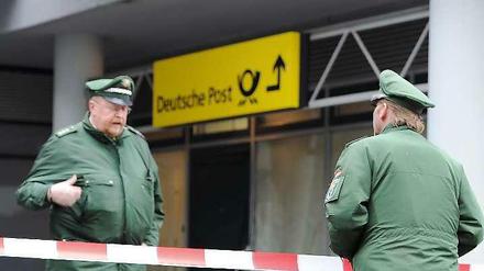 Vor Weihnachten nehmen die Überfälle auf Post- und Bankfilialen zu. Hier stehen Polizisten nach einem Überfall vor einer Post in Lichtenberg (Archivbild). 