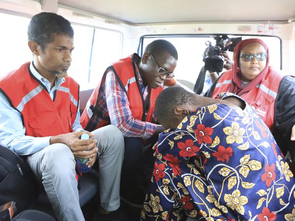 Eine Sektenanhängerin neben Mitgliedern des Kenianischen Roten Kreuzes in einem Auto, nachdem sie von der Polizei in einem Wald gerettet wurde.