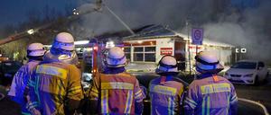 Feuerwehrmänner vor dem ausgebrannten Supermarkt in Treptow.