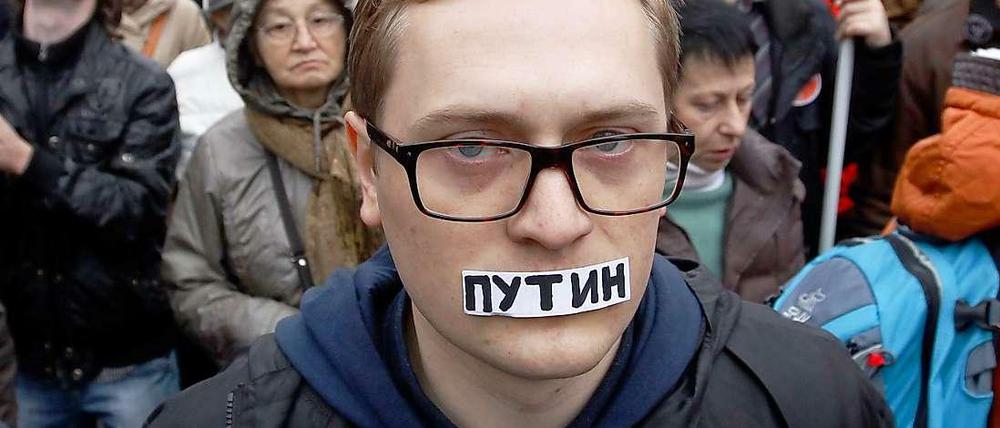Opposition ohne Stimme. Der Name "Putin" verschließt symbolisch den Mund.