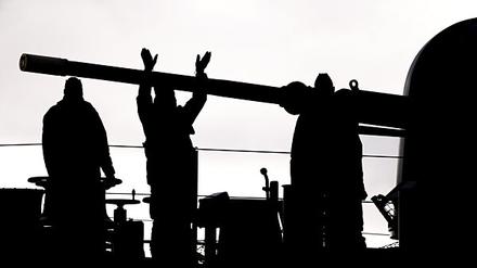 Besatzungsmitglieder der Fregatte „Schleswig-Holstein“ winken ihren Familienangehörigen beim Auslaufen aus dem Hafen zu.
