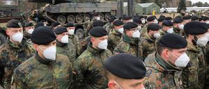 Soldiers of the German armed forces Bundeswehr take part in a ceremony during the visit of the German Defence Minister at the leadership of the NATO's Enhanced Forward Presence "enhanced forward presence" (EFP) battlebroup in Rukla, Lithuania, on February  22, 2022. (Photo by PETRAS MALUKAS / AFP)