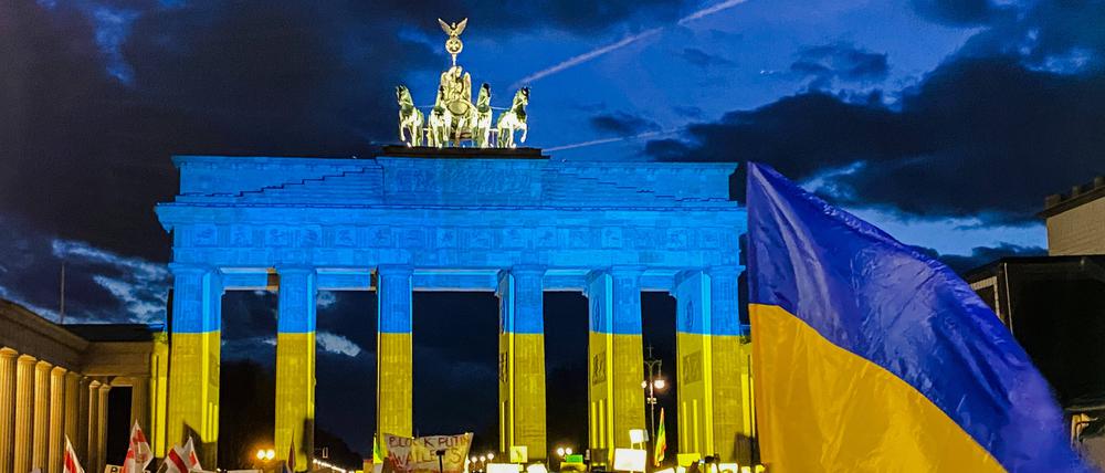 Demonstration vor dem angestrahlten Brandenburger Tor anlässlich der Kriegserklärung von Putin an die Ukraine.