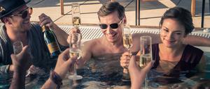 Gerry Falkland (Frederick Lau), Viktor Stein (David Kross) und und die Bankkauffrau Nicole Kleber (Janina Uhse) genießen ihr Luxusleben im Pool - eine Szene aus dem Netflix-Film „Betonrausch“.