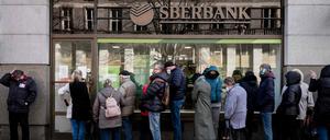 TOPSHOT - People queue outside a branch of Russian state-owned bank Sberbank to withdraw their savings and close their accounts.