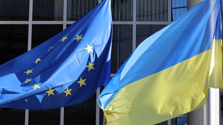 The Ukrainian flag flutters along side the European Union flag outside the European Parliament headquarters to show their support for Ukrania after the nation was invaded on February 24 by Russia, in Brussels on February 28, 2022. (Photo by François WALSCHAERTS / AFP)