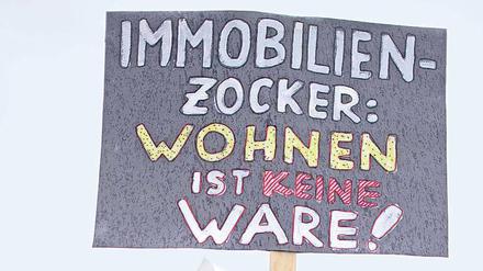 Demonstrant mit Transparent: "Immobilienzocker: Wohnen ist keine Ware!"