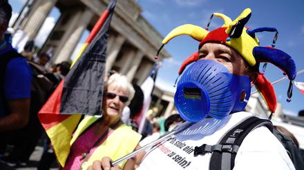 Mit Narrenkappe und Deutschland-Flagge. Demonstration gegen die Corona-Maßnahmen vor dem Brandenburger Tor in Berlin. 