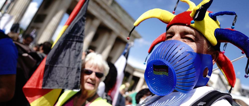 Mit Narrenkappe und Deutschland-Flagge. Demonstration gegen die Corona-Maßnahmen vor dem Brandenburger Tor in Berlin. 