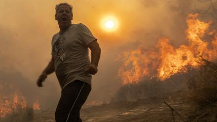 Ein Einheimischer flieht vor den Flammen von einem Waldbrand im Dorf Gennadi auf Rhodos. 