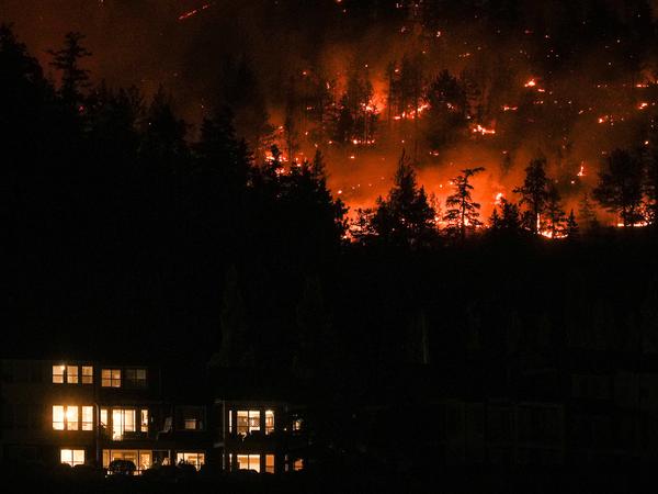 Canada's McDougall Creek wildfire burned Friday in a hillside above a home in West Kelowna.