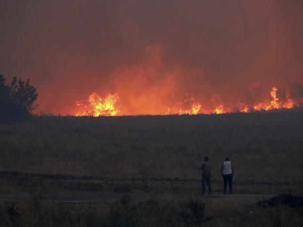 Local residents watch wildfires spread in northeastern Greece. 