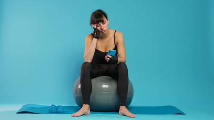 Active person yawning and using smartphone on break from workout.
