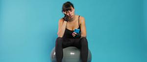 Active person yawning and using smartphone on break from workout.