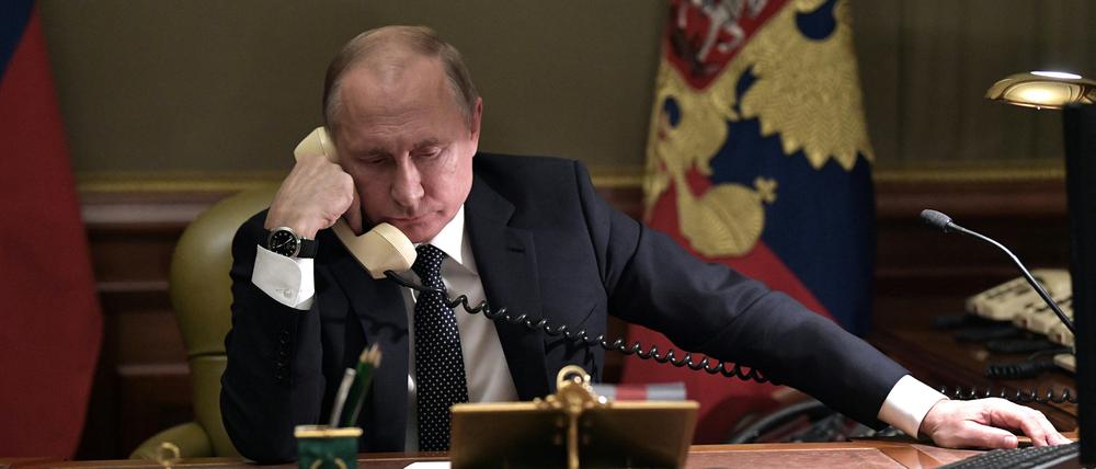 Russian President Vladimir Putin speaks on the phone in his office in Saint Petersburg on December 15, 2018 with Artyom Palyanov -- a boy with brittle bone disease who wished to see a bird's eye view of the city. - Earlier the President promised to make his dream come true by sending him on a helicopter tour of the city. (Photo by Alexey NIKOLSKY / Sputnik / AFP)