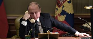 Russian President Vladimir Putin speaks on the phone in his office in Saint Petersburg on December 15, 2018 with Artyom Palyanov -- a boy with brittle bone disease who wished to see a bird's eye view of the city. - Earlier the President promised to make his dream come true by sending him on a helicopter tour of the city. (Photo by Alexey NIKOLSKY / Sputnik / AFP)