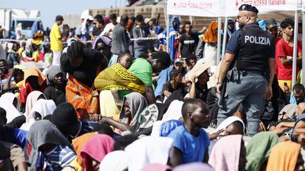 Migranten stehen vor dem Aufnahmezentrum der italienischen Mittelmeerinsel Lampedusa.