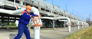 Ein Arbeiter bedient den Gashahn an einer Kompressorstation.