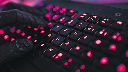 ILLUSTRATION - Ein Mann trägt Handschuhe und tippt auf einer Tastatur. Mehrere Bundestags- und Landtagsabgeordnete sind in den vergangenen Tagen das Ziel von Cyberangriffen geworden - vermutlich aus Russland. +++ dpa-Bildfunk +++