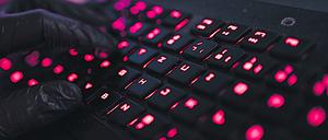 ILLUSTRATION - Ein Mann trägt Handschuhe und tippt auf einer Tastatur. Mehrere Bundestags- und Landtagsabgeordnete sind in den vergangenen Tagen das Ziel von Cyberangriffen geworden - vermutlich aus Russland. +++ dpa-Bildfunk +++