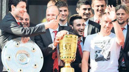 Einer fehlt. Ohne die Champions-League-Trophäe wirken Meisterschale und DFB-Pokal etwas verloren auf dem Rathausbalkon. 